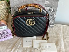 This is black/ red Gucci Marmont - This is a camera bag style bag with diagonal black quilted leather and red leather trim and a bamboo top handle.  This bag is nearly new condition. Please supersize the photos as they are the best description of condition. This bag was carried once so I find it easiest to say slight flaw is possible. I am not noticing any flaws, but there were small item placed inside for a day. I suppose very slight creasing, slight scuffing or indentations on the bag or the hardware is a possibility.  Measurements are approx:8.75"W x 7"H x 3.75"D Questions ? Please ask prior to purchase!! Listing includes: Gucci Marmont with detachable leather shoulder strap, dustbag, booklets in photo and Gucci box. All sales are final. Shipping in the continental USA only.  I do parti Gucci Box, Bamboo Top, Gucci Marmont, Bag Style, Black Quilt, Gucci Black, Quilted Leather, Leather Trim, Find It