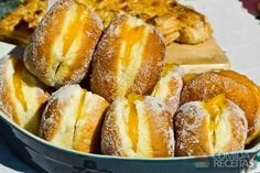 several doughnuts stacked on top of each other in a blue bowl with powdered sugar