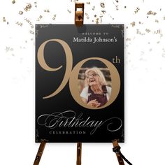 a black and gold 90th birthday card on an easel