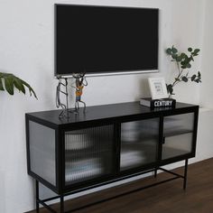 a flat screen tv mounted to the side of a wall next to a wooden floor