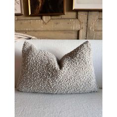 a white pillow sitting on top of a couch in front of a wall with pictures