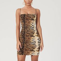 This sexy leopard/tiger print spaghetti strap dress is perfect for a wild night outThe bold animal print adds a touch of edginess, while the spaghetti straps create a playful and flirty vibeMade from high-quality and comfortable fabric, this dress is designed to hug your curves and flatter your figure. Dress it up with heels and statement jewelry for a glamorous look, or keep it casual with sneakers and a denim jacket for a more laid-back vibe. Whatever your style, this dress is sure to make you Figure Dress, Wild Night, Sleeveless Skirt, Leopard Dress, Spaghetti Strap Dress, Body Con Skirt, Tiger Print, Mid Length Dresses, Types Of Skirts