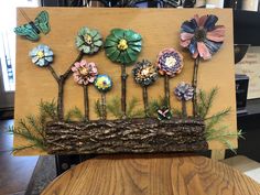 a wooden sign with flowers and butterflies on it