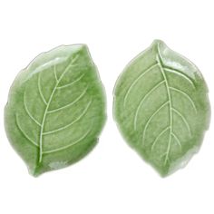 two green leaf shaped plates sitting on top of each other