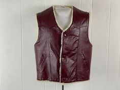 "Vintage 1970s Cowboy Western vest. Made of cordovan (red/brown) leather with synthetic fleece lining. Has a three button front and two waist pockets. No manufacturer's label, marked size 44, about a size large. Actual measurements are:  44\" at the chest   42\" at the waist   18\" shoulder to shoulder   25\" overall length In very good condition." Sleeveless Western Winter Outerwear, Vintage Red Vest For Winter, 1970s Cowboy, Cowboy Vest, Western Vest, Western Vintage, Vintage Vest, Coat Vintage, Mens Vests