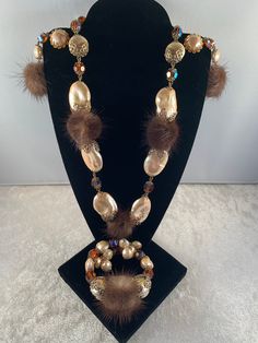 "This is an extremely glamorous RARE Hobé parure consisting of a necklace, earrings and spring-wrap bracelet. All pieces are made from of faceted (orange) aurora borealis crystal beads, brown mink 'fur-balls', and large baroque pearls each with their own filigree caps (large and small). The necklace measures just over 18\" (open) including the beaded extender (3-3/4\") - the shepherd's hook is signed Hobé.  The spring-wrap bracelet (around 6-1/2\") will fit most wrist sizes and the earrings dangle to 2-3/4\". I would place this set as either late 1950's or the 1960s because of the presence of AB stones. The condition of the set is wonderful vintage (near perfect) and these sets are highly collectible and, again, VERY rare.  A truly collectible Hobé set that cannot wait to meet its new luck Elegant Brown Festive Jewelry, Elegant Brown Evening Jewelry, Orange Aurora, Spring Wraps, Aurora Borealis Crystal, Brown Jewelry, Floral Pins, Mink Fur, Earrings Dangle