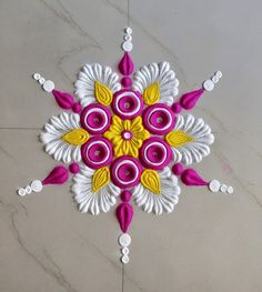 an intricate design on the floor with white and yellow accents, including pink flowers in center