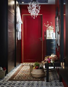 a room with red walls and a chandelier hanging from the ceiling