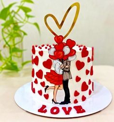 a cake decorated with hearts and a couple holding each other