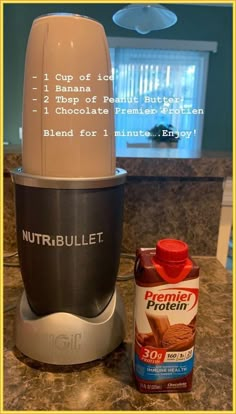 a blender sitting on top of a counter next to a bottle of nut butter