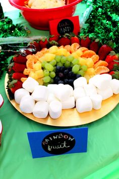 a platter with marshmallows, grapes, strawberries and oranges