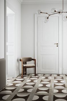 a chair sitting in front of a white door next to a wooden chair on top of a tiled floor