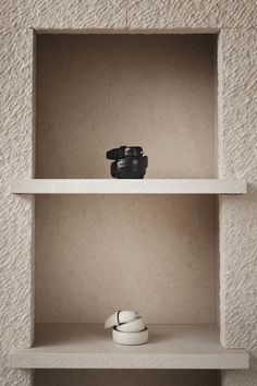 an empty shelf with two pairs of shoes on it and one pair of camera in the middle