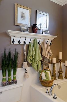 a bathroom with towels hanging on the wall and other items in front of it,