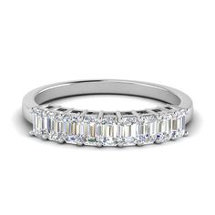 an emerald cut diamond ring on a white background