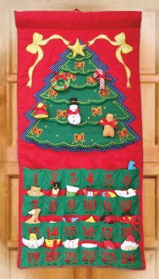 a christmas tree hanging on the wall with ornaments and decorations around it's base