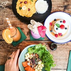 two plates of food on a table with drinks and utensils next to them