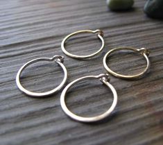 "These tiny little hoop earrings are handmade and comfortable for sleeping in. Buy a set of our tiny artisan hoops earrings made from 20 gauge wire and save. You will receive one pair of sterling silver and one pair of 14k gold filled. They measure about 1/2\" round, comfortable for sleeping in. Due to their dainty size they need to be opened from side to side to get them in your piercings. Do not pull the circle open or they will lose their shape. We also offer more sizes in our store. All of o Minimalist Sterling Silver Small Hoop Septum Ring, Small Hoop Sterling Silver Septum Ring, Minimalist Tiny Hoop Septum Ring, Minimalist Small Hoop Septum Ring, Tiny Minimalist Small Hoop Septum Ring, Minimalist Handmade Small Hoop Nose Rings, Handmade Minimalist Small Hoop Septum Ring, Minimalist Handmade Small Hoop Septum Ring, Dainty Nickel-free Small Hoop Septum Ring