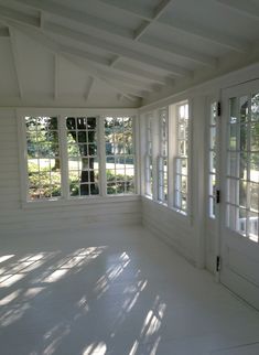 an empty room with white walls and windows