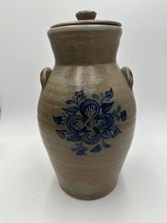 a brown vase with blue flowers on it