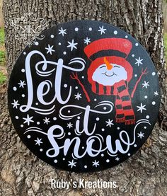 a wooden sign that says, let it snow on the side of a tree trunk