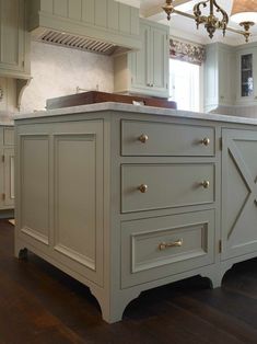 a large kitchen with an island in the middle and cabinets on both sides that are painted gray