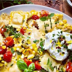 a white plate topped with pasta covered in cheese and veggies next to a fork