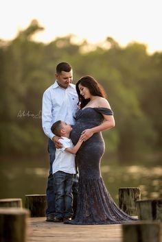 a pregnant woman and her son standing on a dock