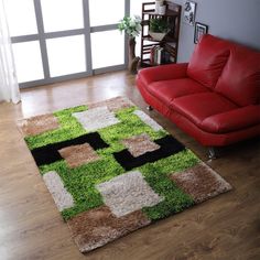 a living room with a red couch and green rug