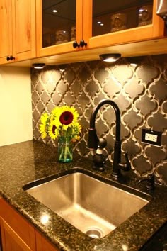 a kitchen sink with a vase of sunflowers on the counter