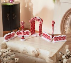 some candy canes are sitting on top of a piece of wood