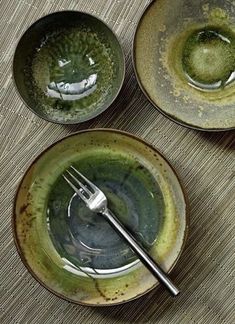 three bowls with forks in them sitting on a table