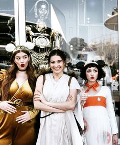 three women dressed in costumes standing next to each other