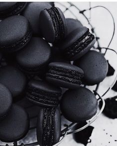 black macaroons in a glass bowl on a table