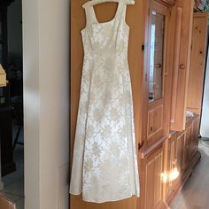 a white dress hanging on a wooden door