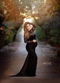 a woman in a black dress standing on a road