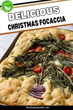 a christmas focaccia with herbs and tomatoes on it in a baking pan