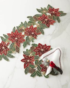 decorative poinsettia with red and green leaves on a white marble countertop