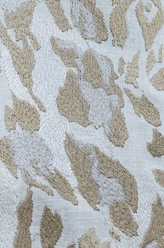 an upholstered fabric with brown and white floral designs on it's edges