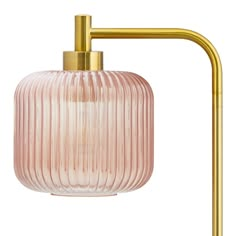 a pink glass and brass lamp on a white background