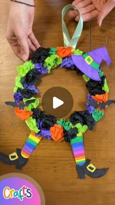 someone making a halloween wreath out of tissue paper