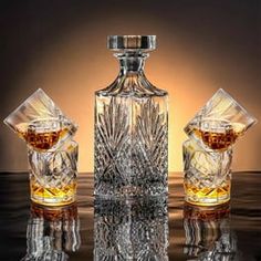 an empty glass bottle sitting on top of a table next to two crystal vases