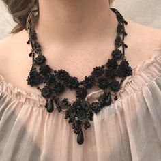 Beautiful Black Beaded Bib Necklace. This necklace has a distinctive Downton Abby feeling.Made with jet black glass beads and handpainted resin flowers. Studded with clusters of beaded posies in a lace like pattern. So pretty and reminiscent of Victorian Jewelry from the turn of the century. The flowers are hand sewn together with hand painted resin flowers and glass beads. The chain is also beaded in a complex beading pattern. Lovely with matching necklace below. This is a quality piece of jewe Black Bohemian Beaded Necklaces For Weddings, Handmade Black Necklace For Evening, Black Bohemian Beaded Necklace For Evening, Bohemian Black Beaded Necklace For Evening, Black Beaded Wedding Jewelry, Black Embellished Jewelry For Evening, Bohemian Black Jewelry For Evening, Elegant Embellished Black Necklace, Elegant Black Embellished Necklace