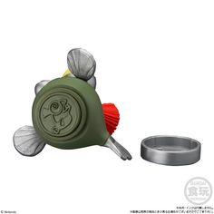 a green toy with a red handle and tail