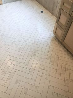 a bathroom with white tile flooring and wooden cabinets