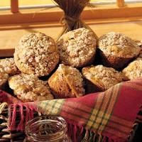 a basket filled with muffins sitting on top of a wooden table next to a blanket