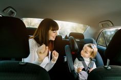 a woman and child in the back seat of a car