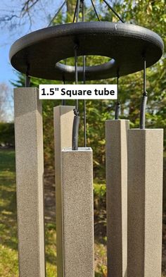 a wind chime with three square tubes attached to it's sides and a sign that says 1 5 square tube