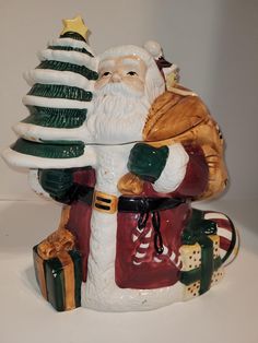 a ceramic santa clause holding a christmas tree