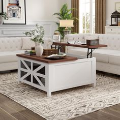 a living room with white couches and wooden tables